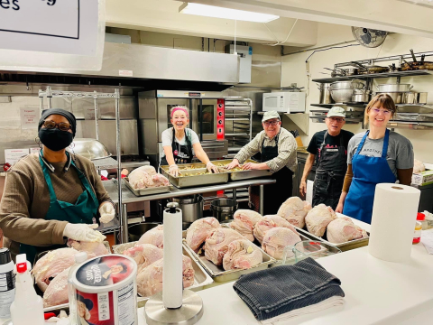Photo of a group of people cooking in a kitchen at the Ravenswood Community Center