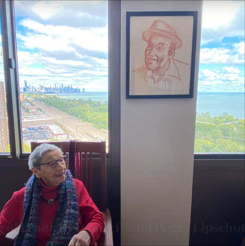 Photo of Retiree Bea Lumpkin sitting in a chair in front of a window with the Chicago skyline in the background